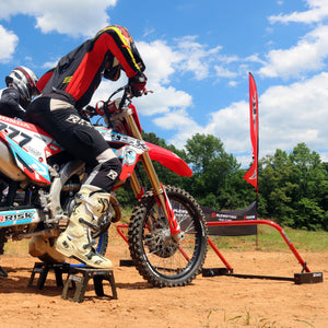 Oudoor picture of two MX riders lined up at Holeshot Pro Gates from a rear 3/4 view